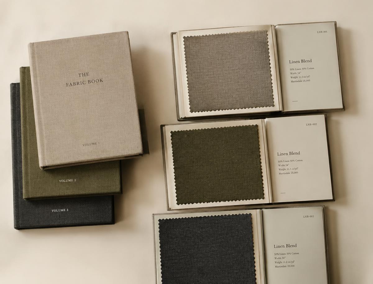 Stacked and open fabric sample books with mounted linen swatches